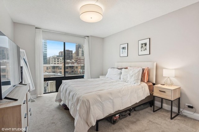 bedroom with light colored carpet and a textured ceiling