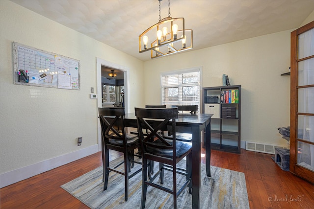 469 Dewey Ave, Galena, IL 61036 - dining area featuring a notable chandelier, wood-type flooring, visible vents, and baseboards