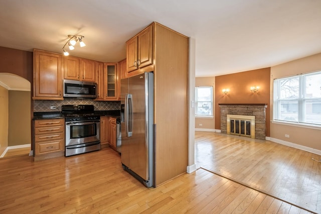 kitchen with backsplash, light hardwood / wood-style flooring, plenty of natural light, and appliances with stainless steel finishes