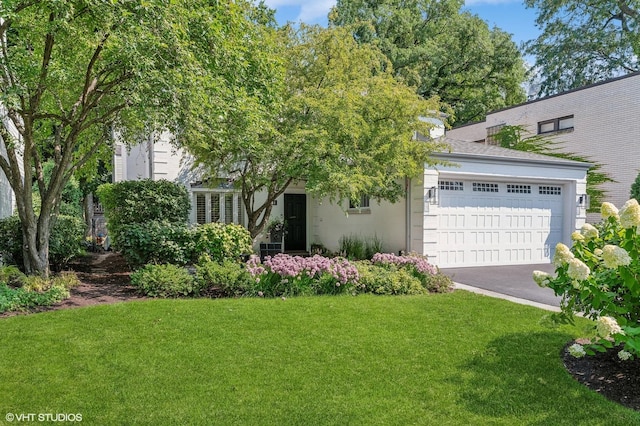 obstructed view of property with an attached garage, driveway, and a front yard