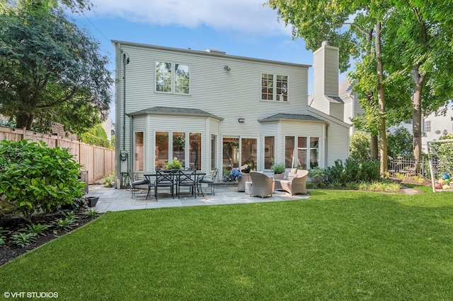 back of house featuring a lawn, a patio area, and fence