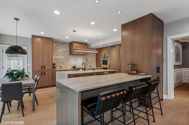 kitchen featuring a spacious island, pendant lighting, a kitchen bar, and modern cabinets