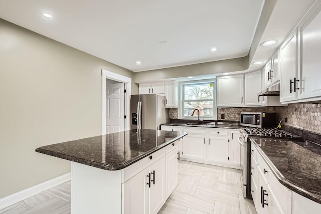 kitchen with white cabinetry, sink, stainless steel appliances, and a center island