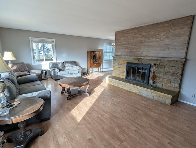 living room featuring a fireplace, wood-type flooring, and baseboard heating