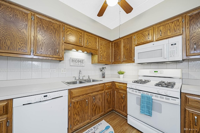 kitchen with sink, backsplash, ceiling fan, light hardwood / wood-style floors, and white appliances