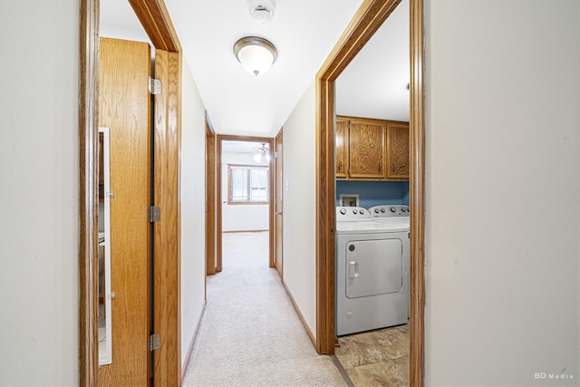 hall with washer and dryer and light carpet