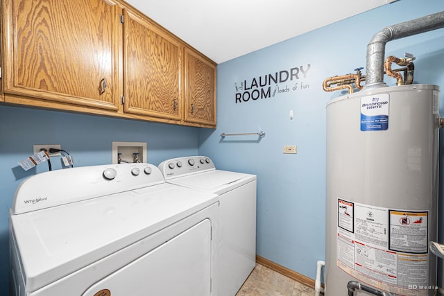 laundry area with cabinets, washing machine and dryer, and water heater