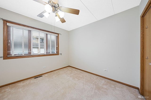 unfurnished room featuring light carpet and ceiling fan