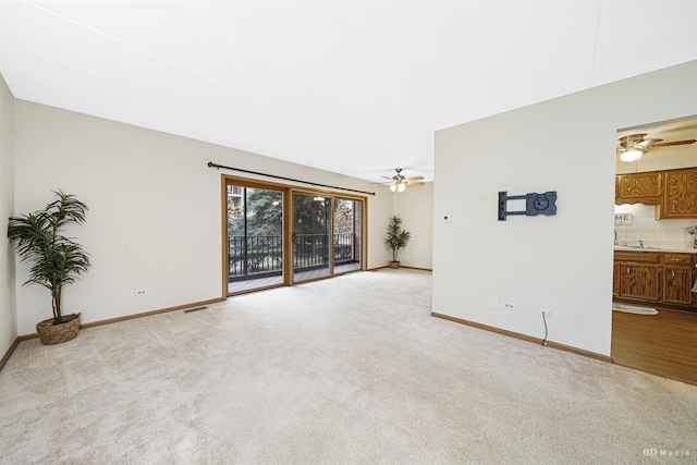 unfurnished living room with ceiling fan and light carpet