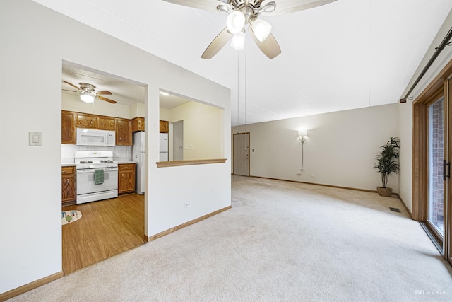 unfurnished living room with light colored carpet and ceiling fan