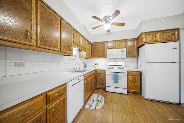 kitchen featuring sink, white appliances, ceiling fan, backsplash, and light hardwood / wood-style floors