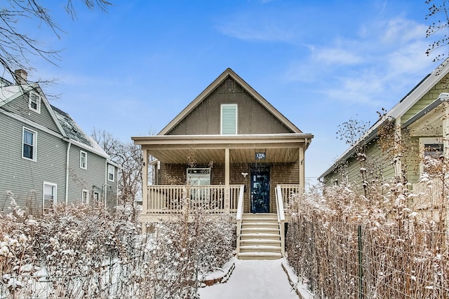 view of front of home featuring covered porch and brick siding