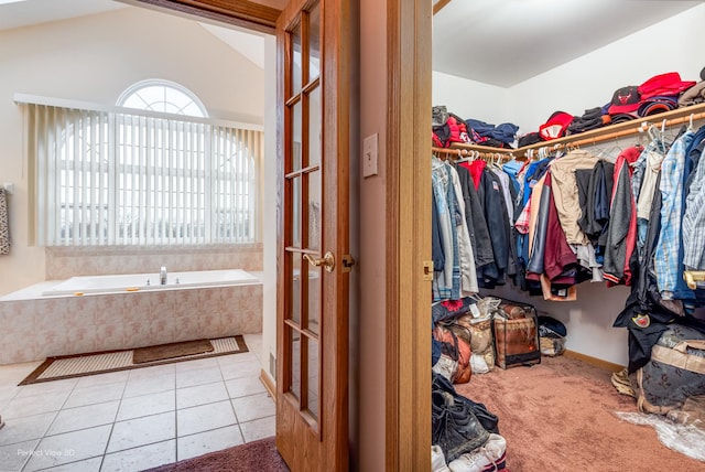 spacious closet with vaulted ceiling and light tile patterned floors