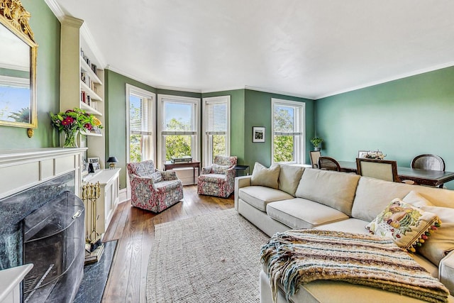 living room with built in features, ornamental molding, hardwood / wood-style flooring, and a premium fireplace