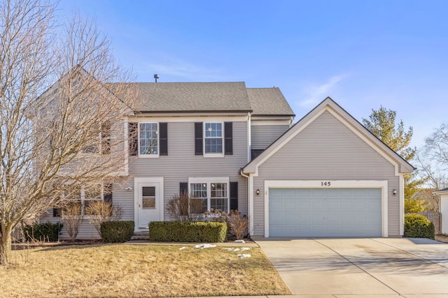 view of front of property with concrete driveway, a shingled roof, an attached garage, and a front yard