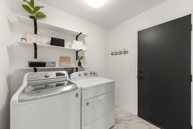 laundry area with laundry area, baseboards, and separate washer and dryer