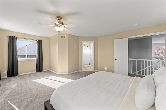 bedroom featuring baseboards, multiple windows, visible vents, and light colored carpet