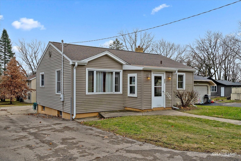 view of front of house featuring a garage and a front lawn