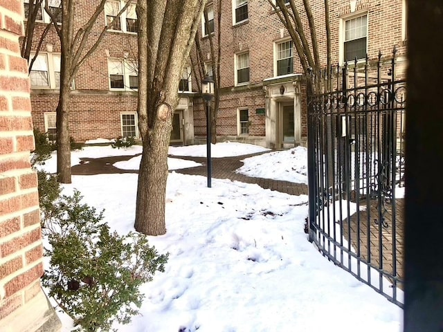 yard covered in snow featuring a gate