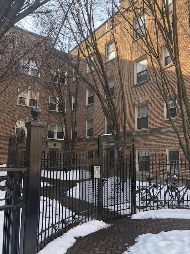 snow covered gate featuring a fenced front yard