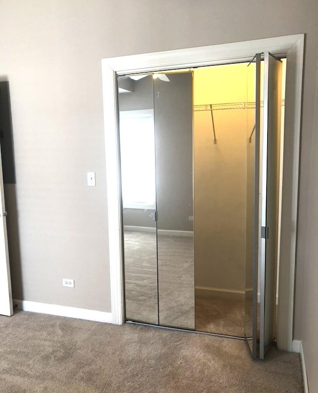 unfurnished bedroom featuring a closet, baseboards, and carpet floors