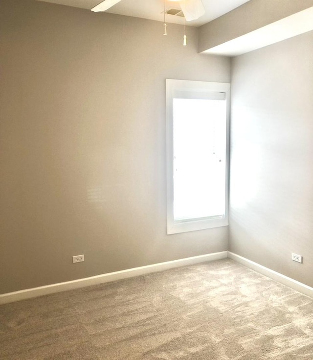 unfurnished room with carpet flooring, a ceiling fan, and baseboards