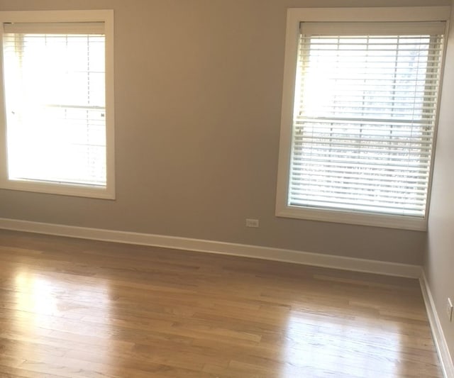 empty room featuring baseboards and wood finished floors