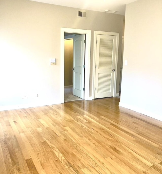 empty room with visible vents and light wood-style floors