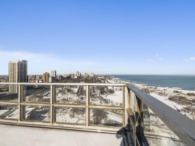 balcony featuring a view of the beach and a water view