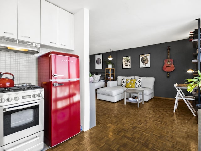 kitchen featuring stainless steel gas stove, dark parquet flooring, tasteful backsplash, and white cabinets