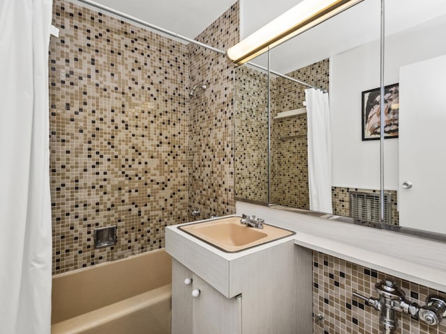 bathroom with tasteful backsplash, shower / tub combo with curtain, and vanity