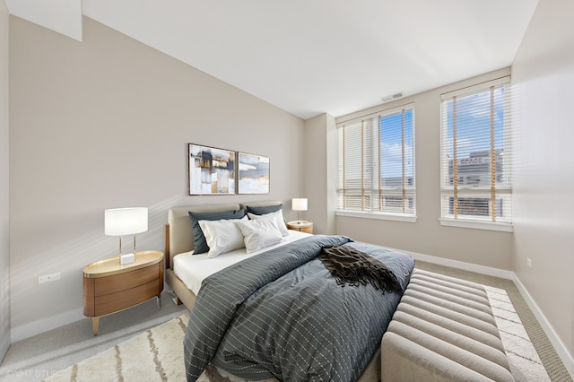 bedroom with multiple windows and light colored carpet