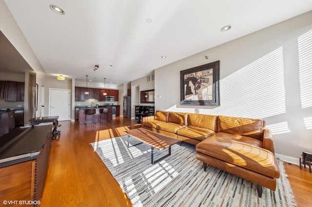 living room featuring sink and light hardwood / wood-style floors