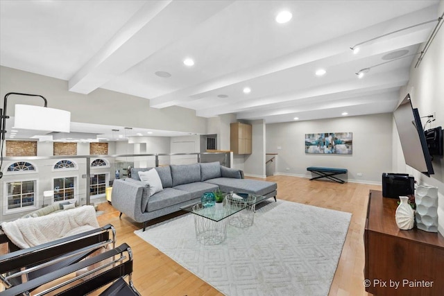 living room featuring beamed ceiling and light hardwood / wood-style floors