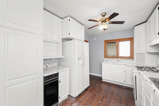 kitchen with white appliances, baseboards, white cabinets, a ceiling fan, and dark wood-type flooring