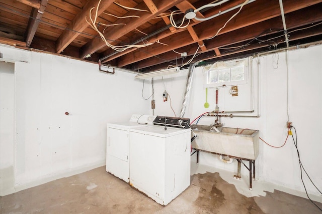 clothes washing area featuring laundry area, washer and clothes dryer, and a sink