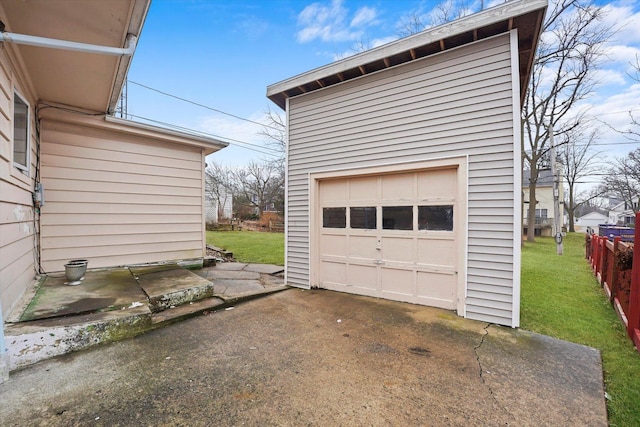 detached garage featuring driveway and fence