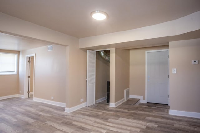 unfurnished room with visible vents, baseboards, and wood finished floors