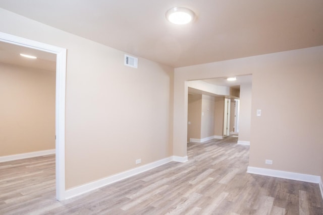 spare room with visible vents, light wood-style flooring, and baseboards