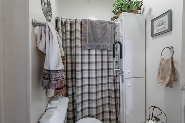 full bathroom with toilet and a shower with shower curtain