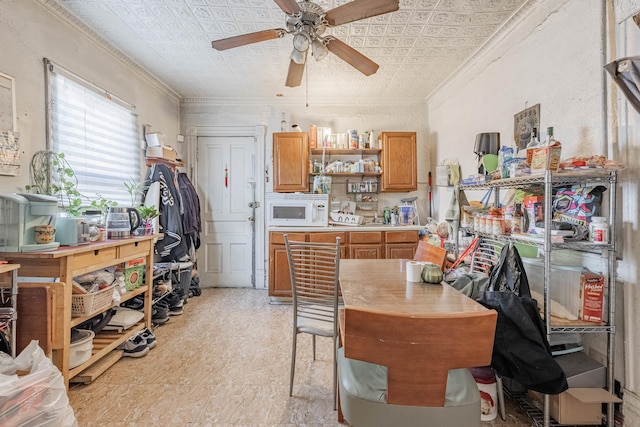 kitchen with white microwave, an ornate ceiling, open shelves, and crown molding