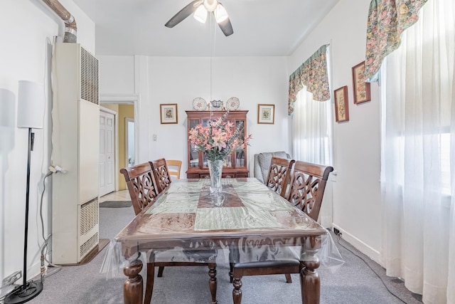 carpeted dining area with ceiling fan and baseboards