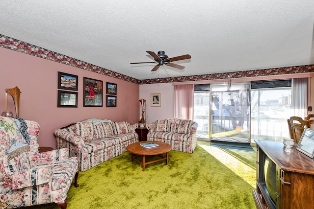 carpeted living room featuring ceiling fan and a textured ceiling