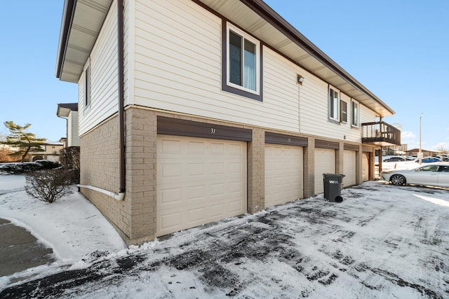 view of snowy exterior with a garage