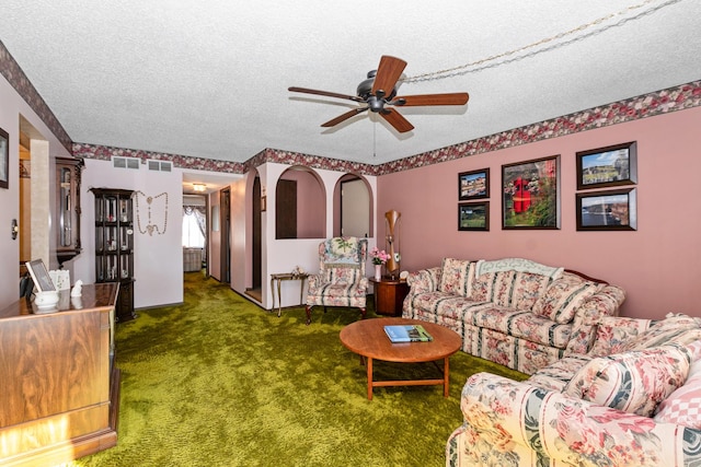 living room with ceiling fan, a textured ceiling, and carpet