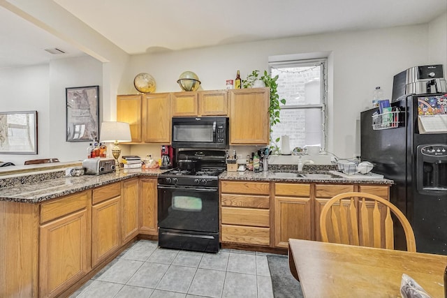 816 N Hermitage Ave, Chicago, IL 60622 - kitchen with black appliances, light tile patterned floors, a sink, dark stone countertops, and a peninsula