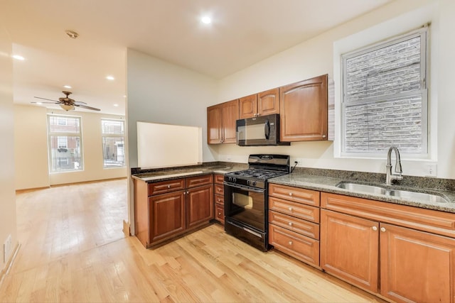 816 N Hermitage Ave, Chicago, IL 60622 - kitchen featuring black appliances, a sink, dark stone counters, light wood-style floors, and ceiling fan