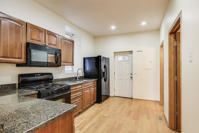 816 N Hermitage Ave, Chicago, IL 60622 - kitchen featuring black appliances, a sink, light wood-style flooring, dark stone counters, and recessed lighting