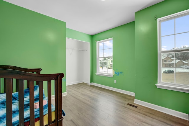 bedroom with light hardwood / wood-style floors and a closet