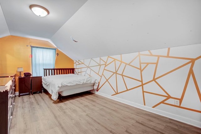 bedroom with vaulted ceiling and light hardwood / wood-style floors